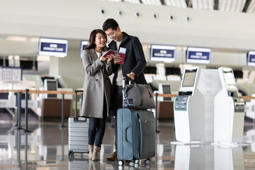Happy young couple with airplane tickets at the airport