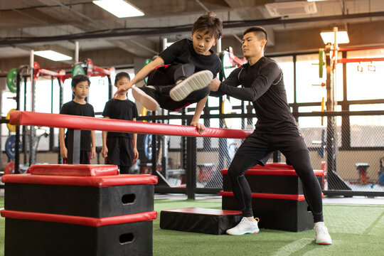 Active children having exercise class with their coach in gym