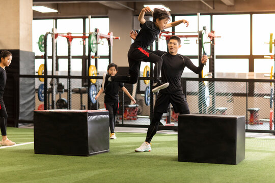Active children having exercise class with their coach in gym