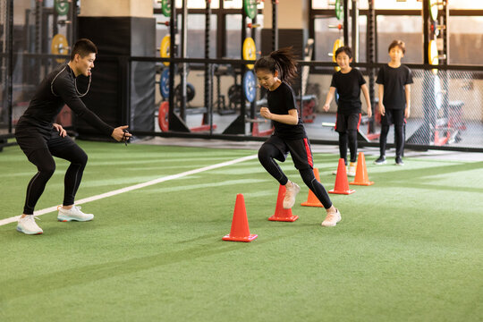 Active children having exercise class with their coach in gym