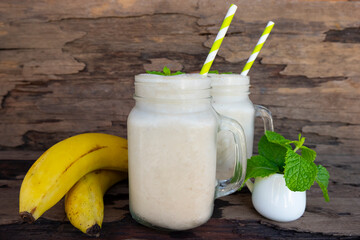 Banana fresh cocktail vanilla smoothies  fruit juice beverage healthy the taste yummy in glass drink episode good morning on wooden background from the top view.