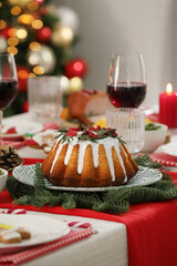 Festive dinner with delicious cake served on table indoors. Christmas Eve celebration