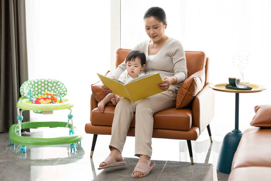 Happy grandmother and baby reading picture book