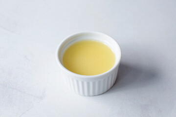 A view of a ramekin condiment cup of lemon juice.