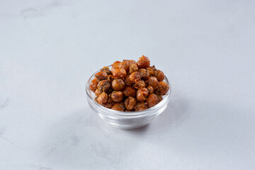 A view of a glass cup of fried garbanzo beans.