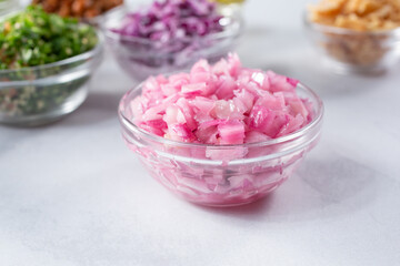A view of a glass cup of minced red onion.