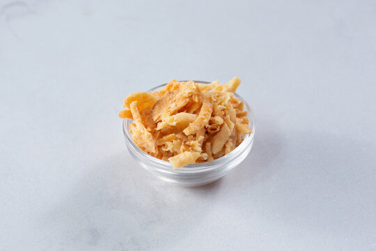 A View Of A Glass Condiment Cup Of Deep Fried Onions Or Fried Tortilla Strips.