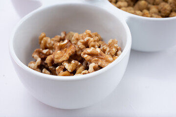 A closeup view of a party tray bowl full of walnuts. 