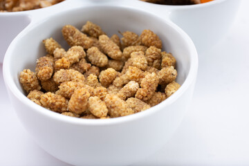 A closeup view of a bowl of dried mulberries.