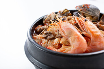 A closeup view of a bowl of Korean soft tofu soup, featuring shrimp.