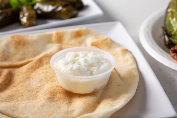 A view of a plate of pita bread with garlic sauce.