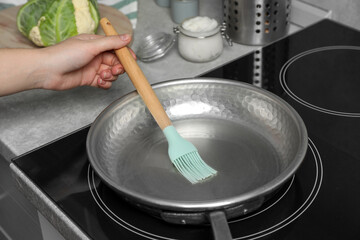 Woman cooking with coconut oil on induction stove, closeup