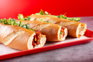A view of a three banh mi sandwiches on a tray.