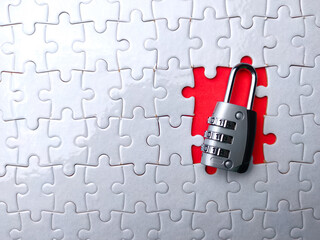 Selective focus. Padlock and jigsaw puzzle with copy space on a red background.