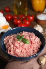 Raw chicken minced meat with basil and ingredients on table