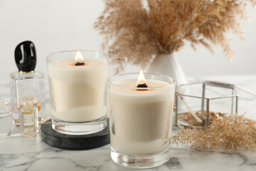 Fototapeta na wymiar Composition with burning soy candles on white marble table