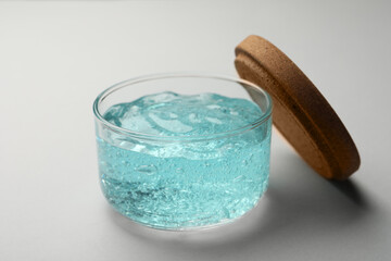 Jar of blue cosmetic gel on light background