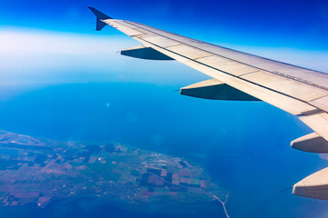 View from the airplane window at a beautiful blue clear sky and the airplane wing