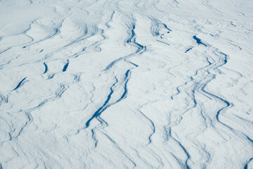 Snow texture with snow waves. Winter nature background.