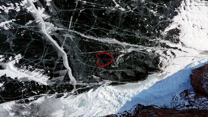 A heart made of fabric lies on the cracked ice of frozen Lake Baikal. Olkhon Island