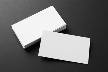 Blank business cards on black background, above view. Mockup for design