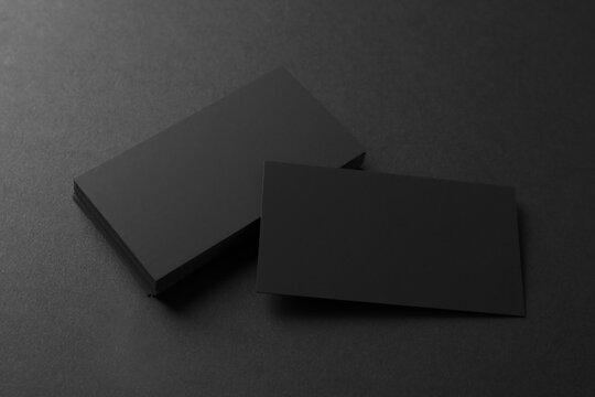 Blank business cards on black background, above view. Mockup for design