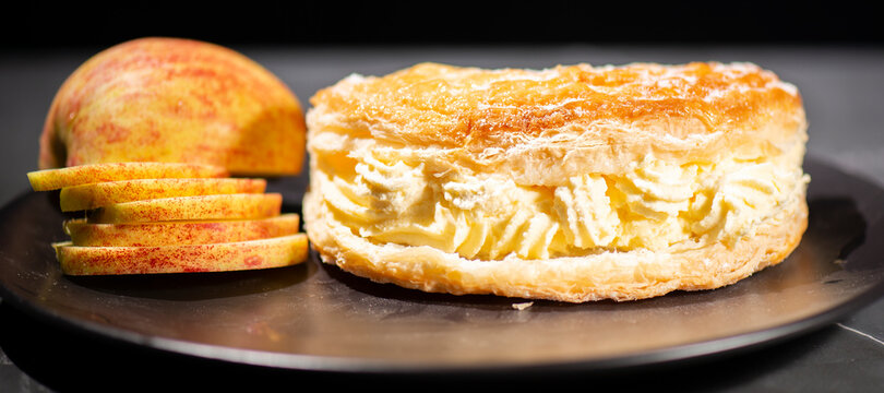Flaky sweet puff pastry turnover with diced apple and fresh whipped cream