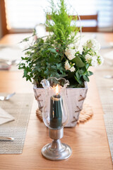 Holiday table decoration with candles and plants