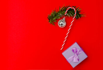 Caramel cane with Christmas and New Year decorations top view next to purple gift boxe. space for text