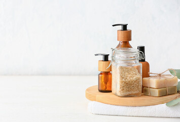 Spa set with bottles of cosmetics on light background
