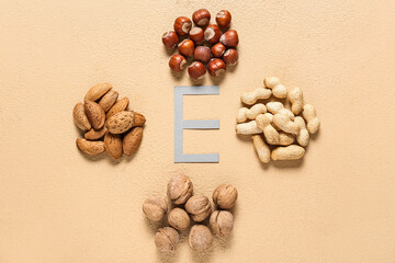 Letter E with different nuts on color background