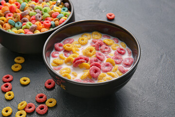 Bowls of colorful cereal rings on dark background