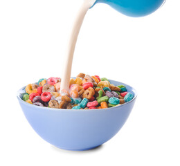Pouring milk in bowl of colorful cereal rings on white background
