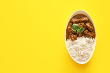 Plate with tasty beef curry and rice on color background