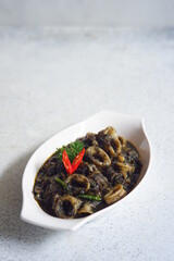 Fototapeta na wymiar squid cooked in black sauce in a white plate