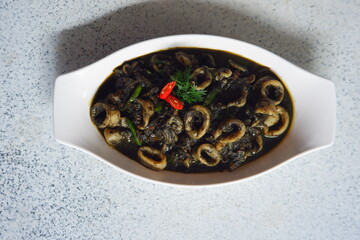 Obraz na płótnie Canvas squid cooked in black sauce in a white plate