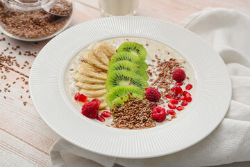 Tasty yoghurt with fruits and flax seeds in bowl on table