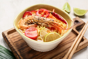 Bowl of tasty Thai soup on grunge background