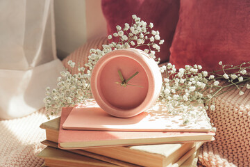 Notebooks, alarm clock and beautiful gypsophila flowers on floor in room, closeup