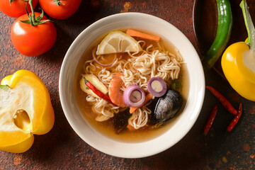 Bowl of spicy Thai soup on color background
