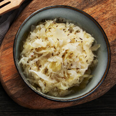 Sauerkraut on wooden background.