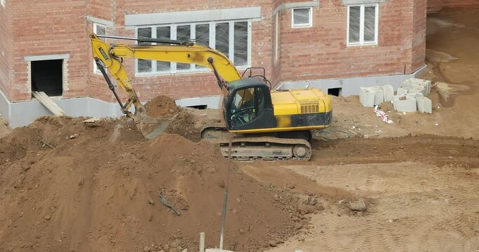 The excavator transports the earth at the construction site. Front-end loader using bucket.