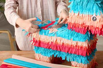 Woman making traditional Mexican pinata at table