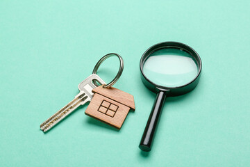 Key from house with magnifier on blue background