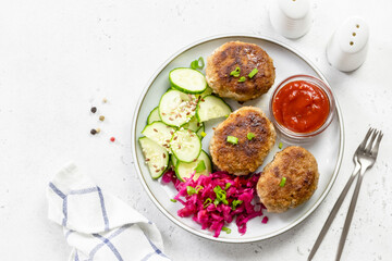 Turkey rissoles, sauerkraut, cucumber salad, ketchup. Top view, copy space.