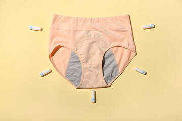 Period panties and tampons on color background