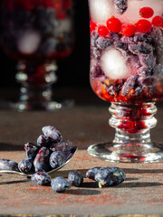 refreshing cocktail with berries and ice on a dark background 