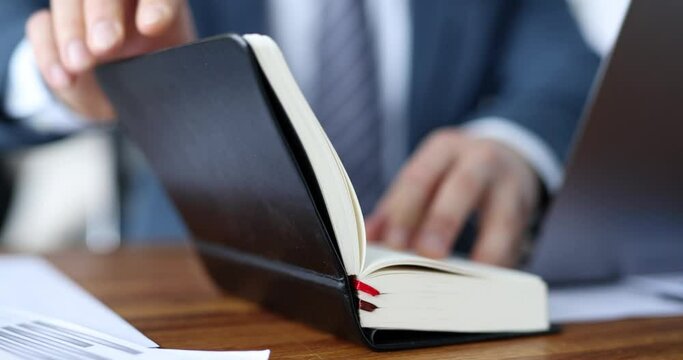Businessman opens daily planner at workplace slow motion 4k movie