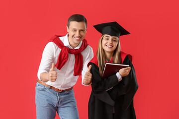 Happy female graduation student with her father on color background