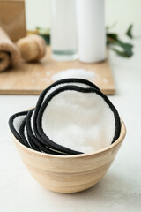 Bowl with reusable cotton pads on table, closeup